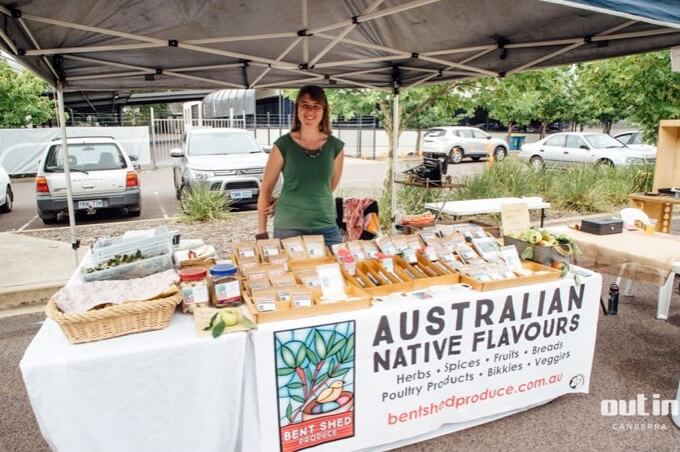 Fiona manning a market stall with the Bent Shed produce banner across the front of the table