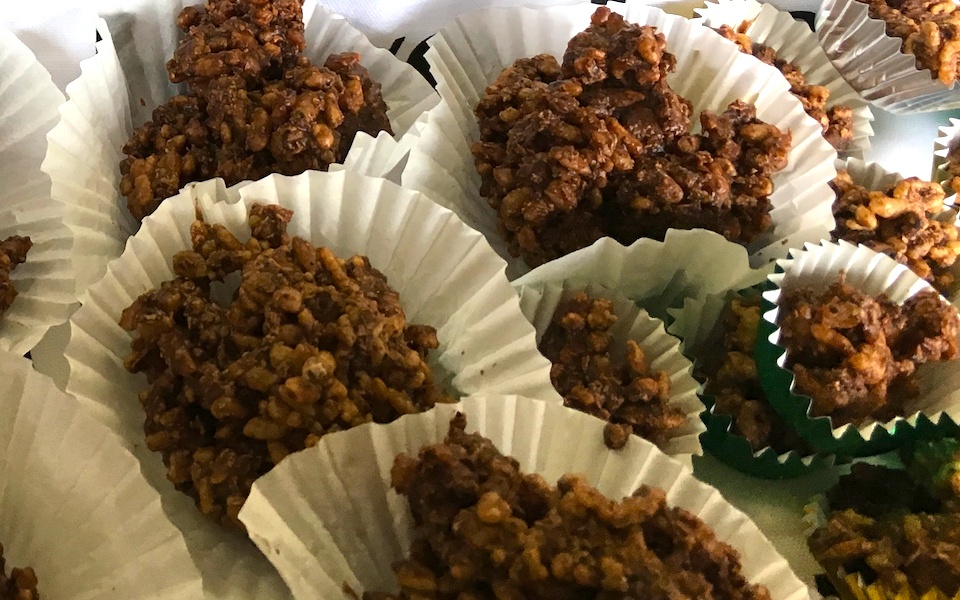 Chocolate-covered rice bubbles sit in white patty cases, looking luscious