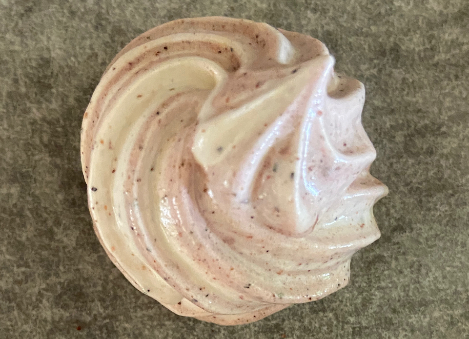 A swirl of a white foodstuff on a pale grey background